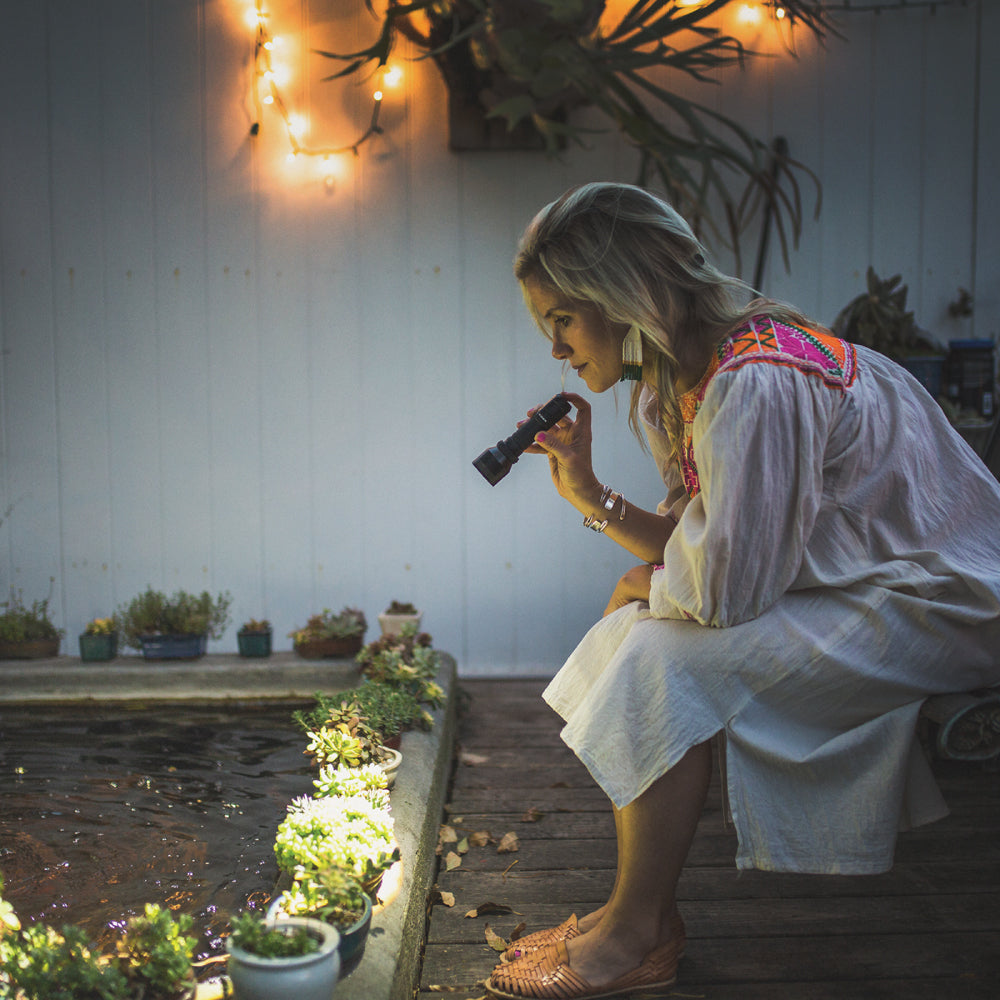 Lady looking at plants with Quality Flashlight 